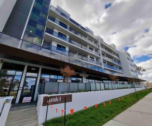 a large building with a sign in front of it at Gungahlin Center-1 Bedroom New Stylish Unit in Harrison