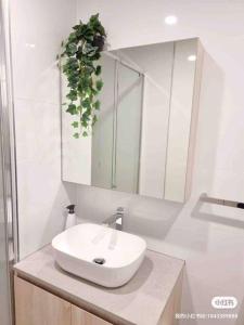 Baño blanco con lavabo y espejo en Gungahlin Center-1 Bedroom New Stylish Unit, en Harrison
