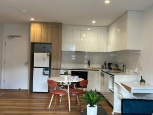 a kitchen with a table and chairs in a kitchen at Gungahlin Center-1 Bedroom New Stylish Unit in Harrison
