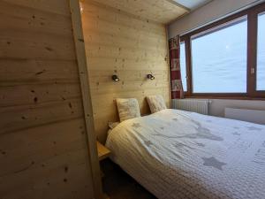 una camera con un letto su una parete in legno di Appartement au lac ski aux pieds a Tignes