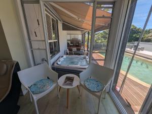 Habitación con piscina, 2 sillas y mesa. en Luxury oasis resort Pet friendly apartment with private pool and spa en Port Macquarie