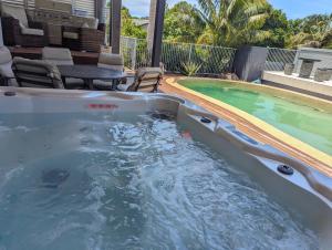 bañera de hidromasaje frente a la piscina en Luxury oasis resort Pet friendly apartment with private pool and spa en Port Macquarie