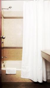 a bathroom with a shower with a white shower curtain at Hotel Mera Mann in Lucknow