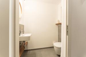 a white bathroom with a toilet and a sink at Appartement Traumblick by Schladming Appartements in Schladming