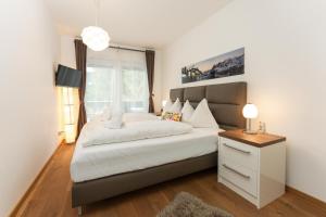 a bedroom with a large white bed and a window at Appartement Traumblick by Schladming Appartements in Schladming
