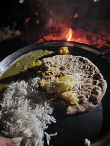 une plaque de nourriture avec du riz et un taco dans l'établissement Hostel Magic Home Stay jaisalmer, à Jaisalmer