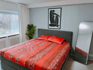 a bedroom with a bed with red pillows on it at Holiday Home 't Groene Hart in Alphen aan den Rijn