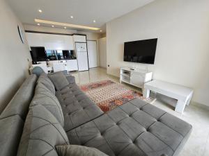 a living room with a couch and a flat screen tv at Konak Tower Seaside in Alanya