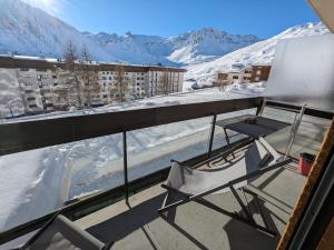 a balcony with a chair and snow covered mountains at Appartement au lac ski aux pieds in Tignes