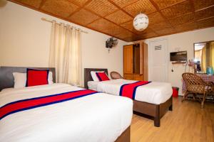 a bedroom with two beds with red and white sheets at The Muglan Hotel and Restaurant in Bhaktapur