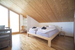 um quarto com uma cama e um tecto em madeira em Chasa Bagnera 174 em Scuol