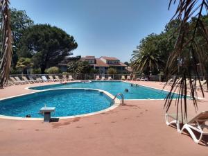 a large swimming pool with chairs and people in it at Vue Golf dans Résidence Nature "SYMPALAPPART" in Moliets-et-Maa