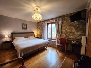 1 dormitorio con cama y pared de piedra en B&B Nord Sud, en Salmchâteau