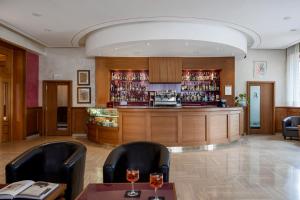 リヴィゾンドリにある5Miglia Hotel & Spaの椅子2脚とテーブル1台が備わるレストラン内のバー