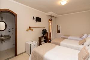 pokój hotelowy z 2 łóżkami i telewizorem w obiekcie POUSADA CAPIM LIMÃO w mieście Diamantina