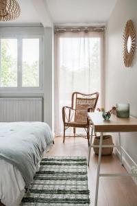 um quarto com uma cama, uma cadeira e uma mesa em Le Jules de Toulouse em Toulouse