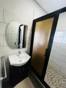 a bathroom with a sink and a mirror at Elisheva apartment in Ndola
