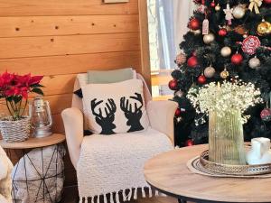 a living room with a christmas tree and a chair at Monte Chalet Kolašin in Kolašin