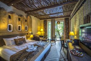 a bedroom with a large bed and a television at Bambara Hotel Premium in Felsőtárkány