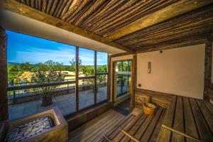 a large room with a balcony with a hot tub at Bambara Hotel Premium in Felsőtárkány