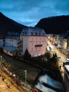a city with a river and a pink building at Appartement cosy et chaleureux in Morez