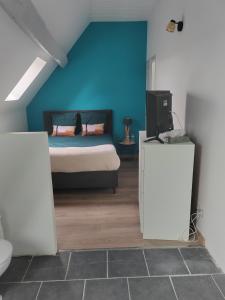 a bedroom with a bed and a blue wall at Chambre d'hôtes Orchidée in Levesville-la-Chenard