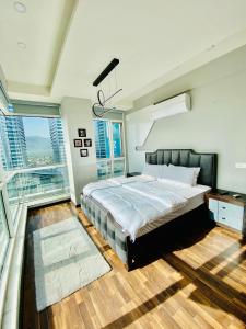 a bedroom with a large bed and a balcony at Cherry On Top-Luxe Living in Islamabad's Skyline Elysium in Islamabad