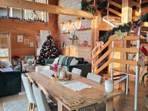 a living room with a wooden table and a christmas tree at Monte Chalet Kolašin in Kolašin