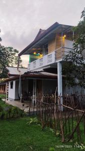 a house with a balcony on top of it at Green House, Upstairs Apartment in Madihe East