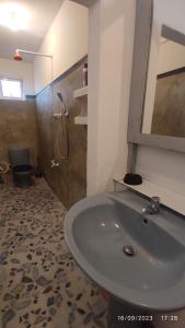 a bathroom with a sink and a shower at Green House, Upstairs Apartment in Madihe East +33 photos
