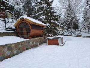 une maison pour chiens avec de la neige dans une cour dans l'établissement Dom nad jeziorem Ublik z sauną i jacuzzi, à Ublik