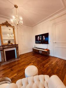 un soggiorno con divano, TV e specchio di élégance à Neuilly : 5 min des Champs Elysées a Neuilly-sur-Seine