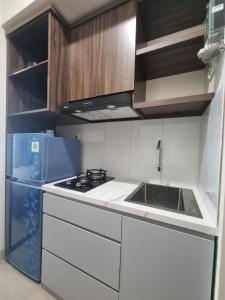 a white kitchen with a sink and a refrigerator at Grand Kamala Lagoon by Armesha in Pekayon Satu