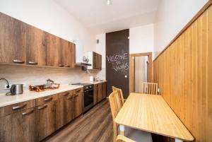 維爾紐斯的住宿－Heart of Senamiestis w King Bed, Full Kitchen，厨房配有木制橱柜和带桌子的木桌