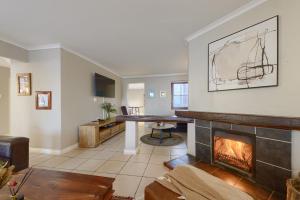 a living room with a fireplace and a table at Moana Bay in Kommetjie