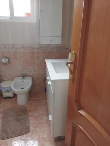 a bathroom with a sink and a toilet and a door at Habitaciónes Privadas Cartagena Murcia in Cartagena