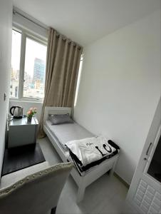 a small bedroom with a bed and a window at Corniche AD - Superb Lovely Room in Abu Dhabi