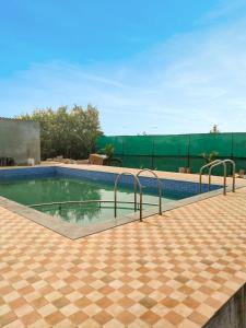 a swimming pool with two metal rails around it at Coastal Paradise in Alibaug