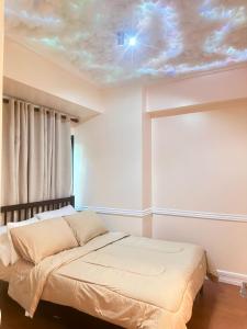 1 dormitorio con 1 cama con techo de nubes en Affordable Staycation Airbnb BGC, en Manila