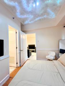 1 dormitorio con 1 cama y TV en el techo en Affordable Staycation Airbnb BGC en Manila