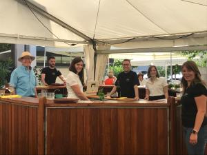 Un groupe de personnes se tenant derrière un comptoir dans l'établissement Gästehaus und Weingut Bernd Frieden, à Nittel