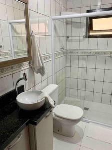 een witte badkamer met een toilet en een wastafel bij Apto Térreo in Blumenau