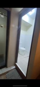 - une vue sur la salle de bains pourvue de toilettes à travers un miroir dans l'établissement INPRO PROPERTY, à Bandung