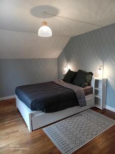 een slaapkamer met een bed met een zwart dekbed bij Maison Éclusière proche de Beauval in Noyers-sur-Cher