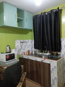 een keuken met een wastafel en een zwart gordijn bij Cozy furnished studio in Nairobi