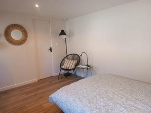 une chambre avec un lit, une chaise et une lampe dans l'établissement Maison studio proche mer, à Pordic