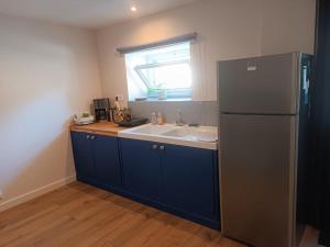 une cuisine avec un évier et un réfrigérateur dans l'établissement Maison studio proche mer, à Pordic