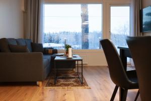uma sala de estar com um sofá e uma mesa em Saimaan Kodikas A3 em Savonlinna