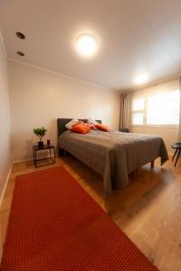 a bedroom with a bed and a red rug at Saimaan Kodikas Premium in Savonlinna +12 photos