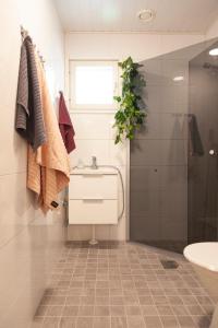 a bathroom with a sink and a shower at Saimaan Kodikas Premium in Savonlinna